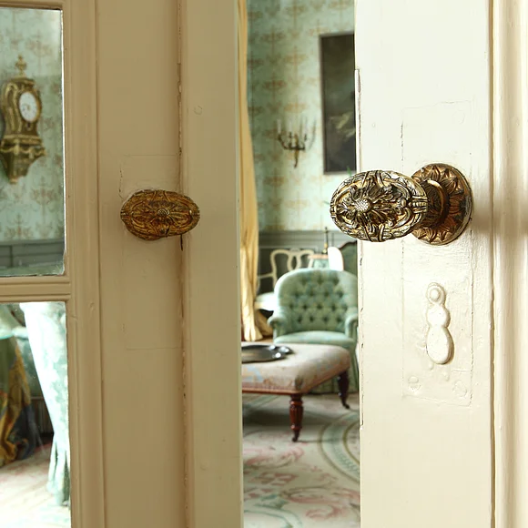 Ein Blick durch die einen Spalt geöffnete Tür in den grünen Salon im Residenzschloss in Oettingen