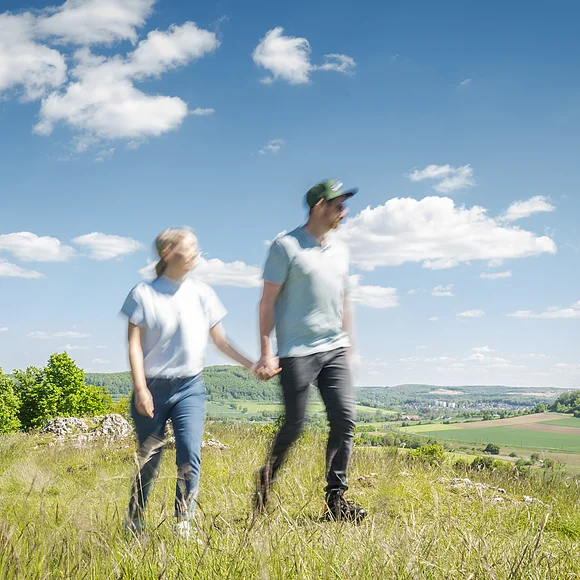 Paar (unscharf) macht einen Streifzug über den Berg mit Blick runter nach Bubenheim/Wettelsheim