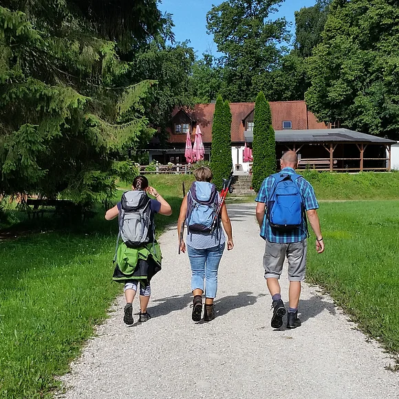 Wanderer auf den letzten Metern zur Einkehr in der Waldschänke Eisbrunn, die im Hintergrund zu sehen ist.
