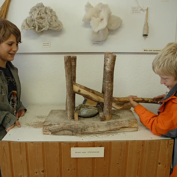 Steinsäge im Goldbergmuseum Zwei Jungen probieren das Model einer Steinsäge im Goldbergmuseum aus.
