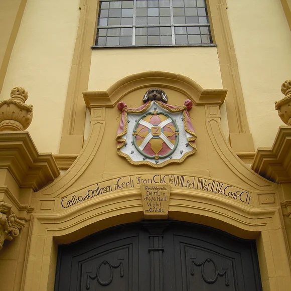 Blick auf das Eingangsportal mit Wappen über dem Tor.
