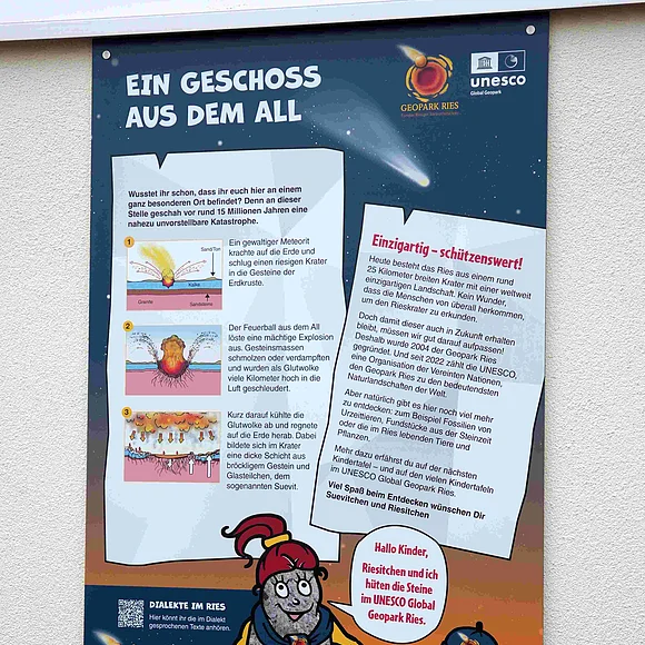 Eine Informationstafel für Kinder erläutert die Entstehung des Rieskraters durch einen Meteoriteneinschlag.