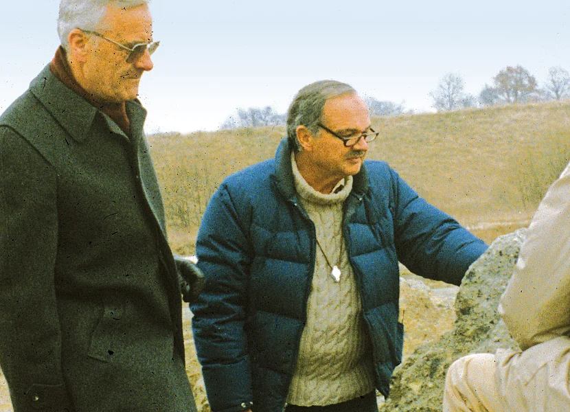 Zwei Männer betrachten einen großen Felsbrocken.