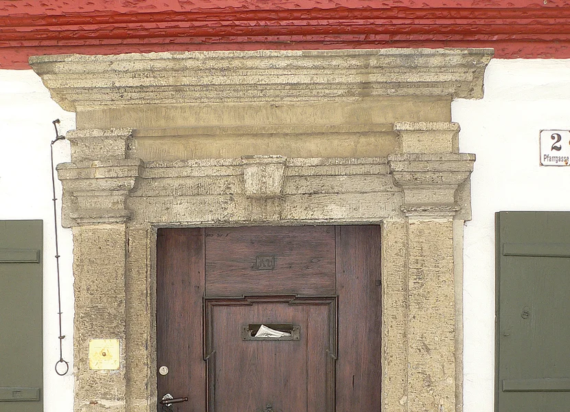 Portale di suevite Das Portal mit Gesims einer Holztür ist aus dem Gestein Suevit gefertigt.