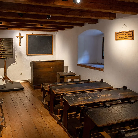 Altes Klassenzimmer mit vielen Bänken und alter Einrichtung