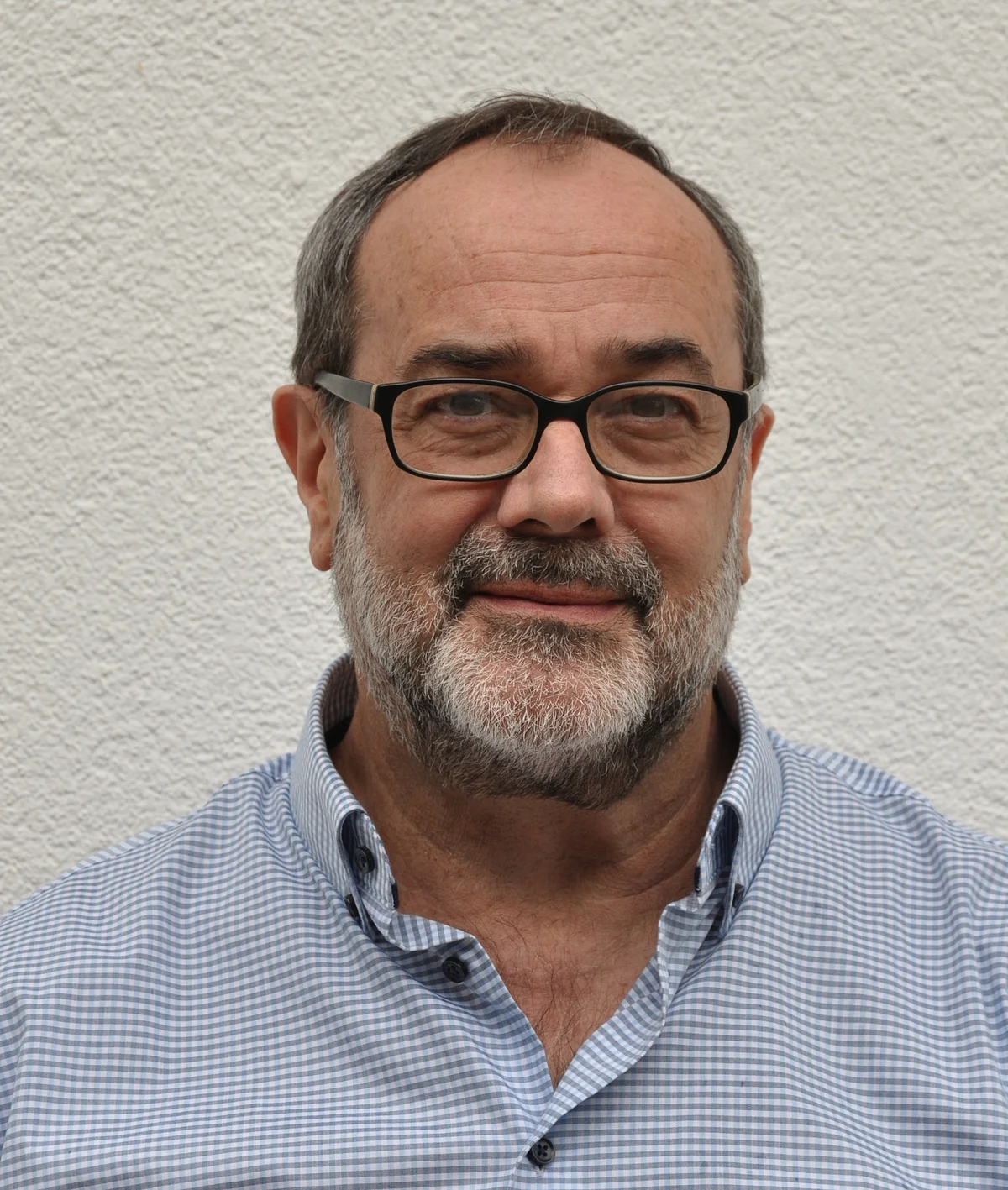 Portrait Prof. Dr. Christian Köberl:Eer hat kurze Haare, trägt eine schwarz umrandete Brille sowie ein weiß-blau karriertes Hemd.