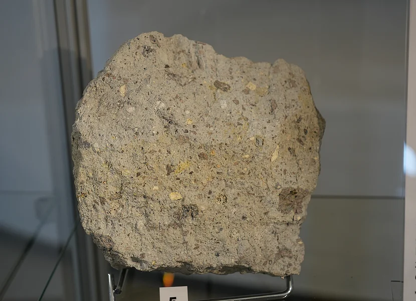 Zu sehen ist ein Stück grauer Suevit aus dem Steinbruch Aumühle mit der Nr. 5.